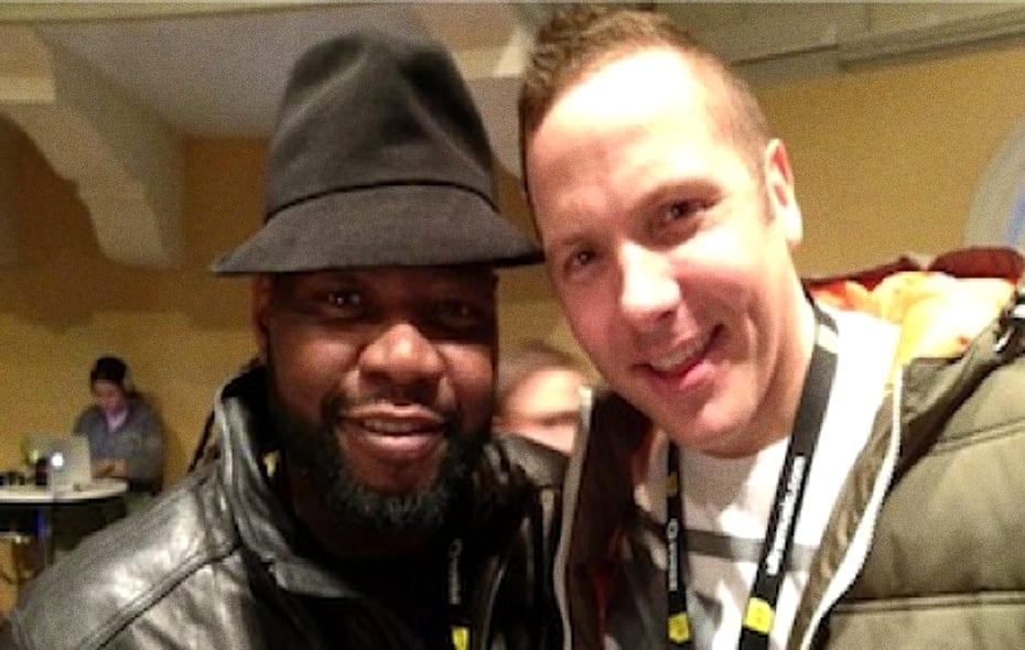 CeCe Rogers in a black trilby and leather jacket, smiling with one of the Soulshaker brothers