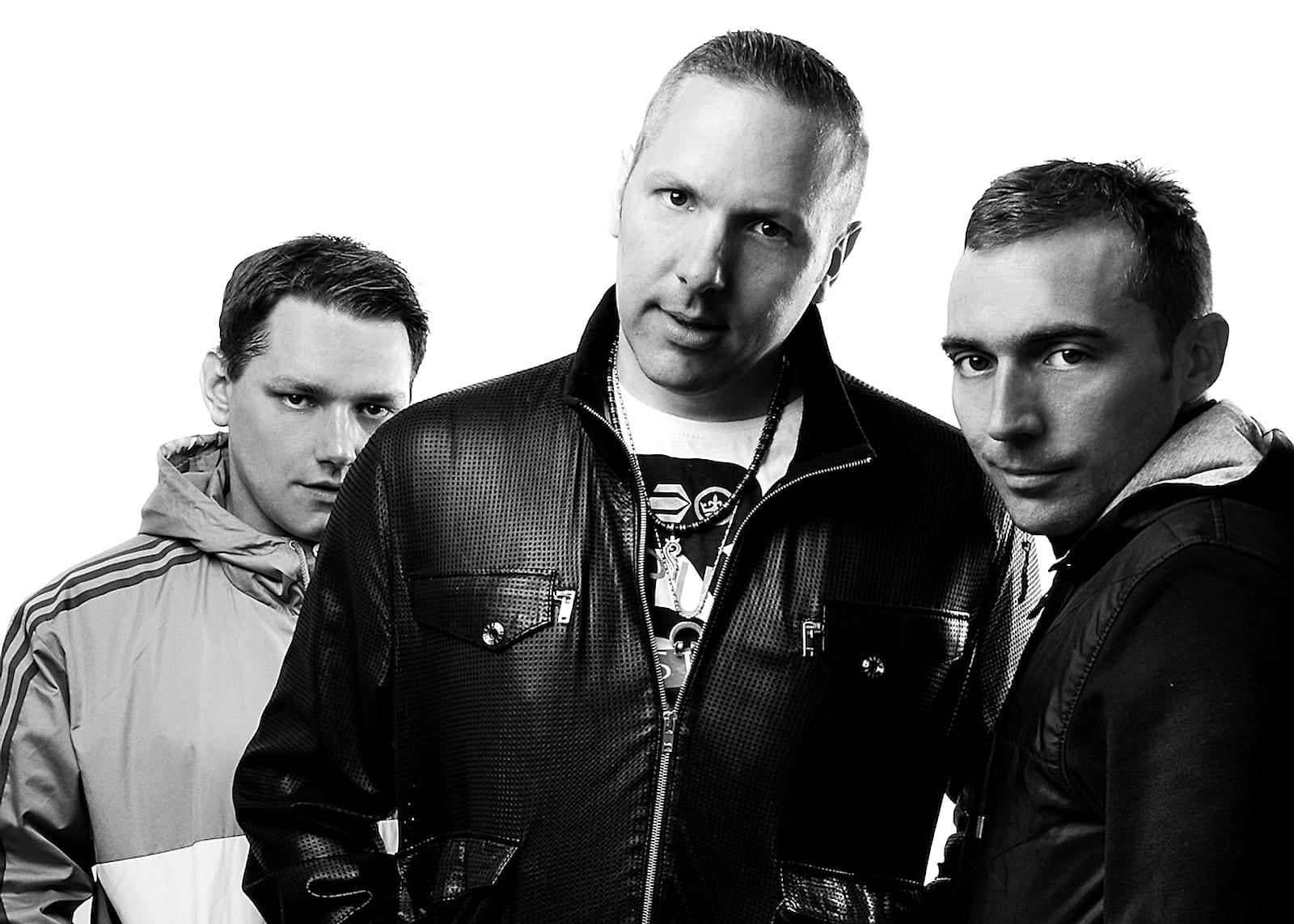 Black-and-white press shot of three men in jackets